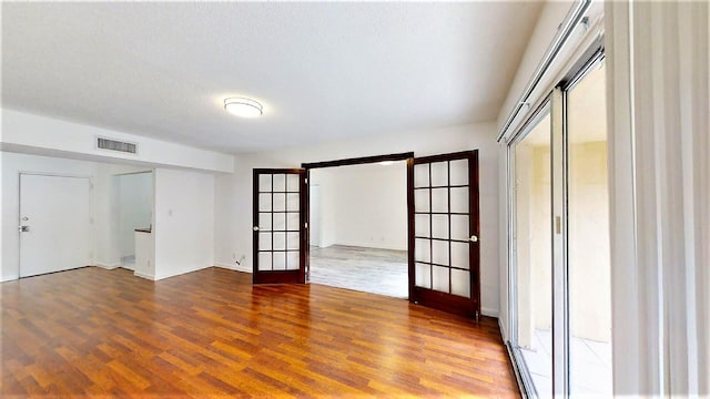 unfurnished room with wood-type flooring and french doors