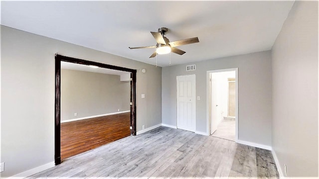 unfurnished bedroom with ceiling fan, connected bathroom, light hardwood / wood-style floors, and a closet