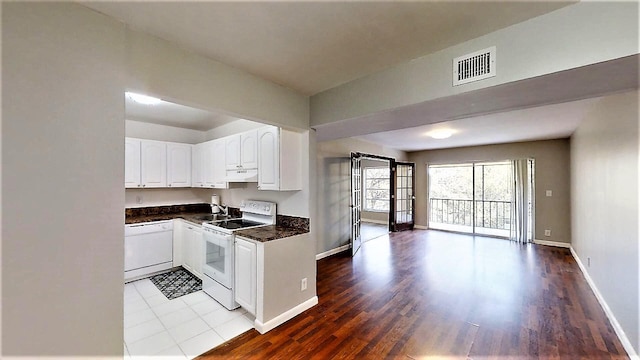 kitchen featuring sink, white appliances, wood-type flooring, and white cabinets