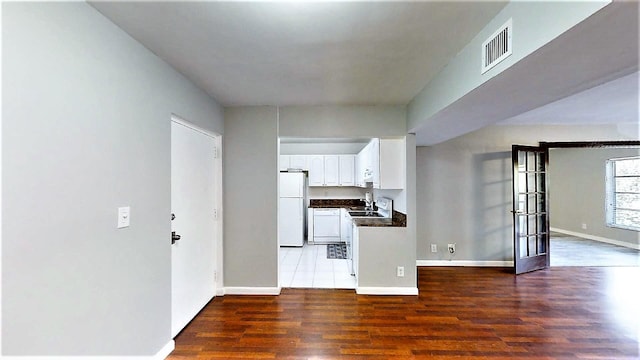 interior space with white cabinetry, white appliances, dark hardwood / wood-style floors, and sink