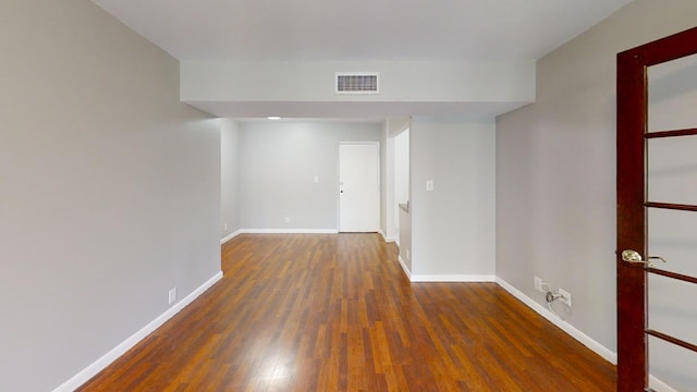 empty room with dark hardwood / wood-style flooring