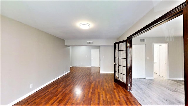 unfurnished room with dark hardwood / wood-style flooring