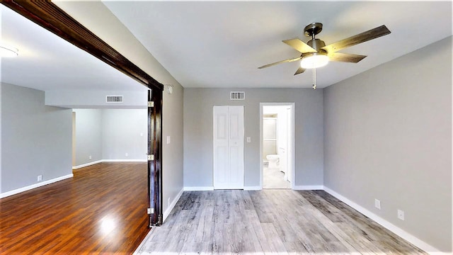 unfurnished bedroom featuring ceiling fan, connected bathroom, and light wood-type flooring