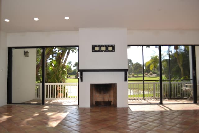 unfurnished living room featuring a healthy amount of sunlight and tile patterned floors