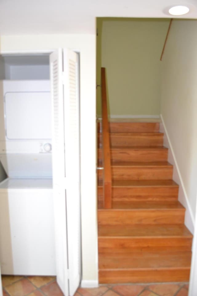 staircase with stacked washer / drying machine and tile patterned flooring