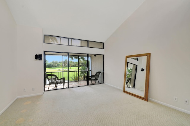 spare room featuring high vaulted ceiling and light carpet