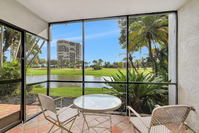 sunroom featuring a water view