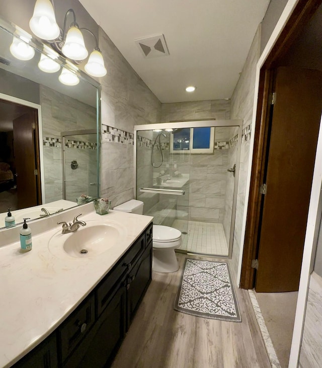 bathroom featuring vanity, toilet, a shower with door, and hardwood / wood-style flooring