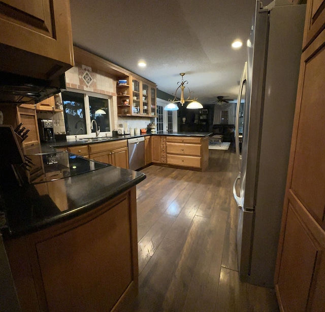 kitchen featuring pendant lighting, stainless steel appliances, ceiling fan, kitchen peninsula, and dark hardwood / wood-style floors