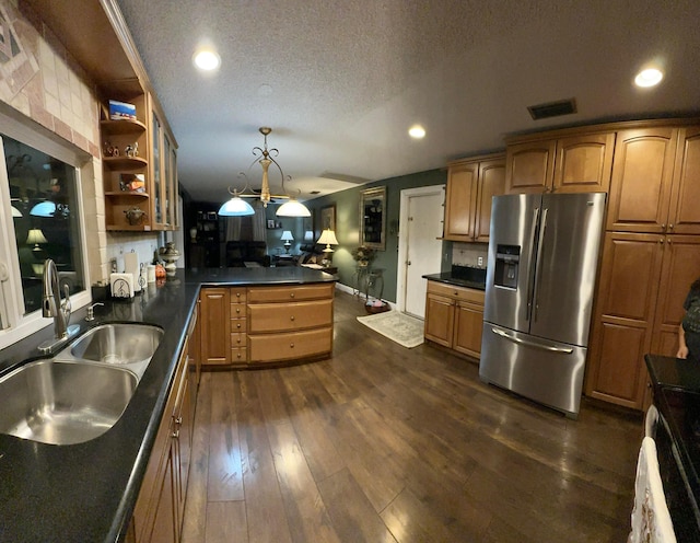 kitchen featuring a textured ceiling, stainless steel fridge with ice dispenser, hanging light fixtures, dark hardwood / wood-style floors, and sink