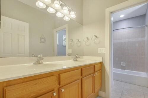 bathroom with vanity, tile patterned flooring, and tiled shower / bath