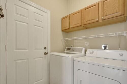 washroom with independent washer and dryer and cabinets