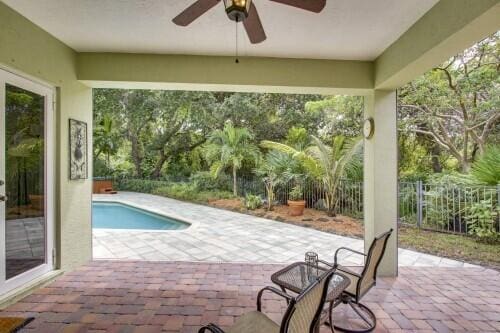 view of swimming pool featuring a patio and ceiling fan