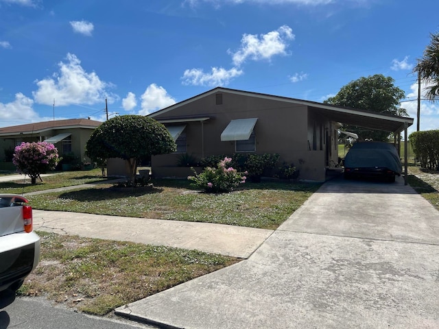 view of front of property featuring a front lawn and a carport