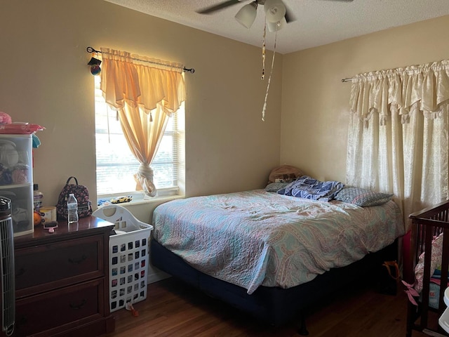 bedroom featuring a textured ceiling, dark hardwood / wood-style floors, and ceiling fan