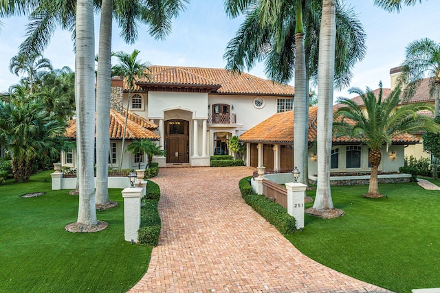 mediterranean / spanish home with a front lawn