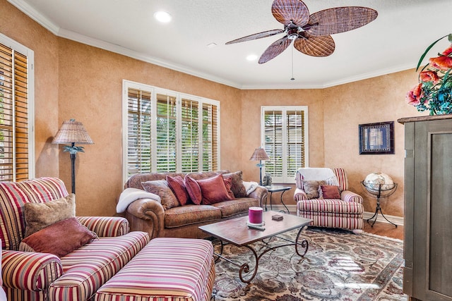 living room with wood-type flooring, ceiling fan, ornamental molding, and a healthy amount of sunlight