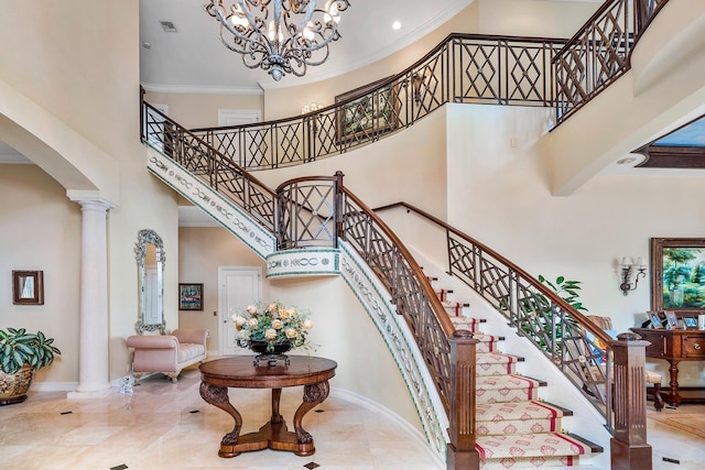 stairway with ornate columns, a high ceiling, and ornamental molding