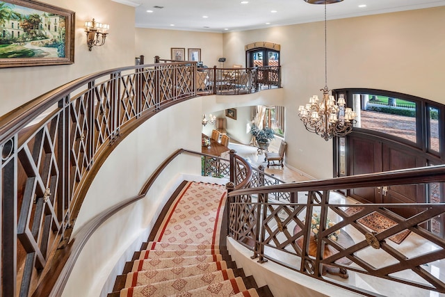 staircase with a notable chandelier and crown molding