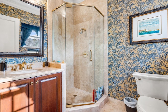 bathroom with vanity, a shower with door, and toilet