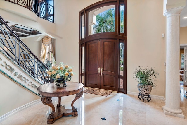 entrance foyer featuring ornate columns and a high ceiling