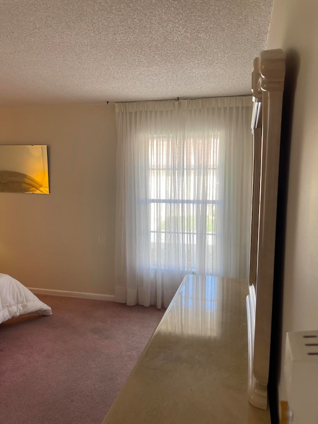 bedroom with a textured ceiling and carpet