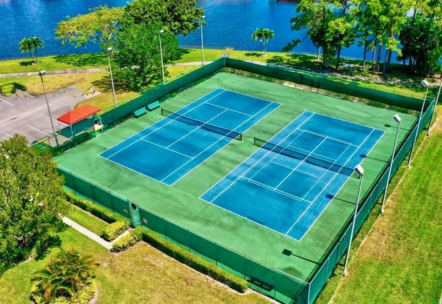 view of tennis court featuring a water view