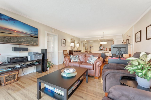 living room featuring crown molding, light hardwood / wood-style flooring, and a textured ceiling