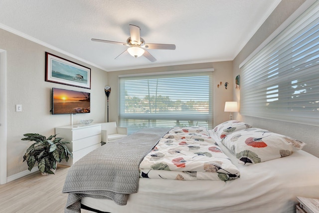 bedroom featuring crown molding, ceiling fan, a textured ceiling, and light wood-type flooring