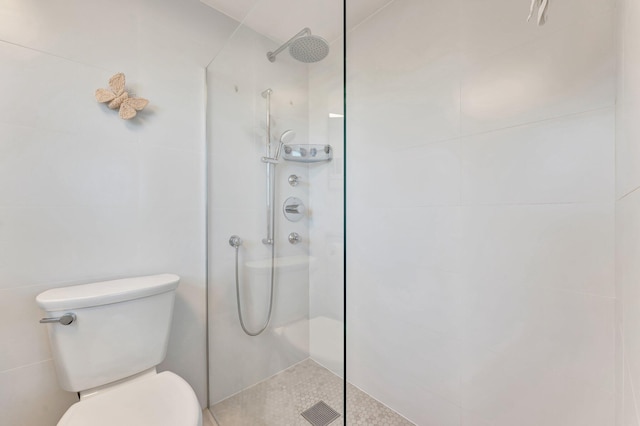 bathroom featuring toilet and tiled shower