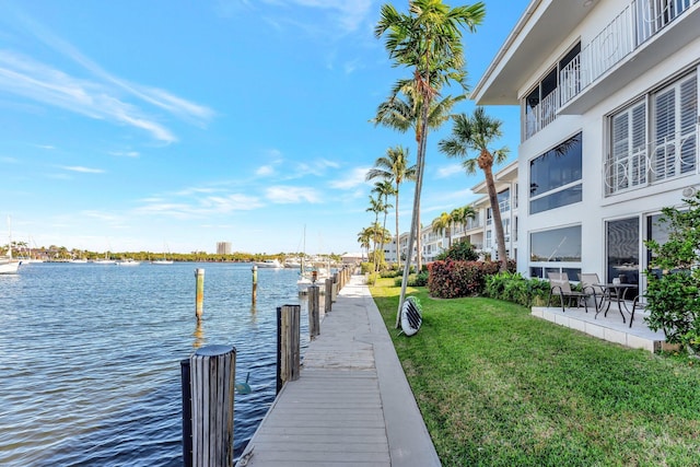 view of dock with a water view and a yard