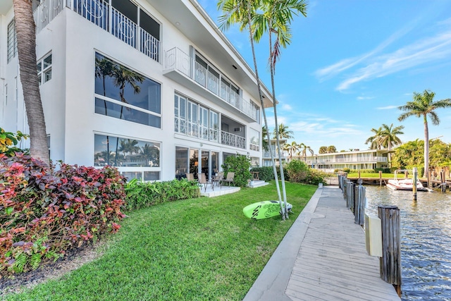 dock area with a water view and a yard