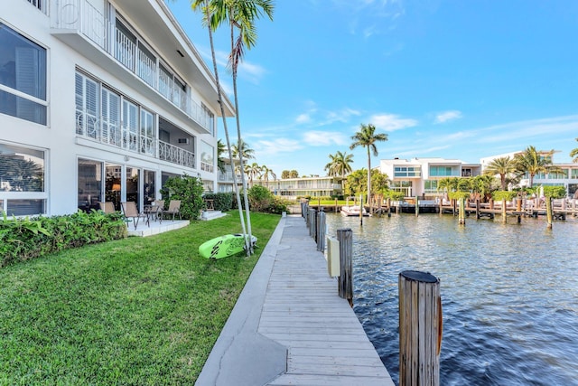 dock area with a water view and a lawn