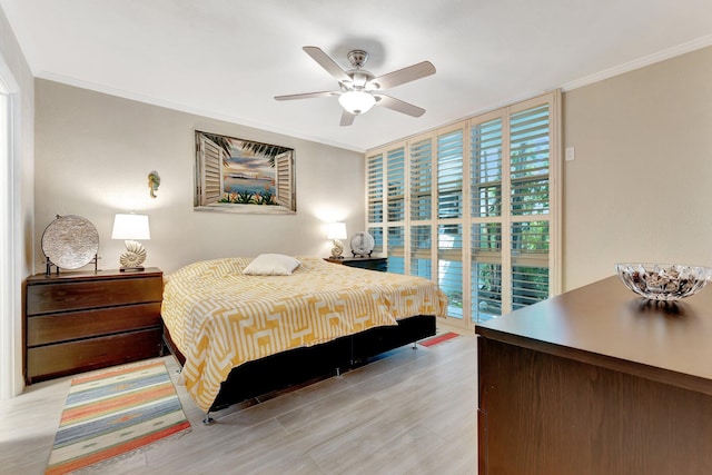 bedroom featuring crown molding, expansive windows, ceiling fan, and light wood-type flooring