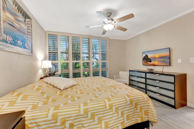 bedroom with crown molding, ceiling fan, and light hardwood / wood-style flooring