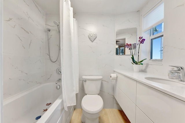 full bathroom with shower / tub combo with curtain, tile walls, hardwood / wood-style floors, vanity, and toilet