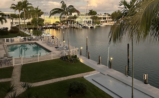 view of dock with a community pool, a yard, a patio, and a water view