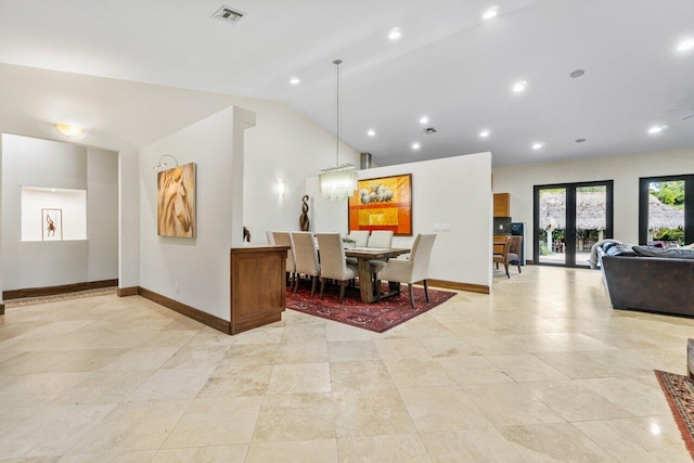 dining area featuring french doors, light tile floors, and lofted ceiling