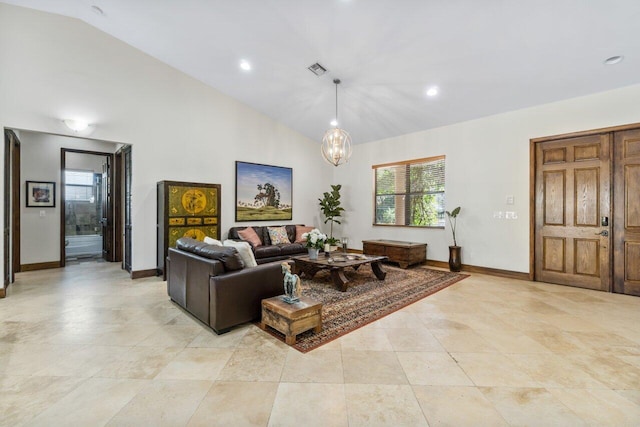 tiled living room featuring an inviting chandelier and vaulted ceiling