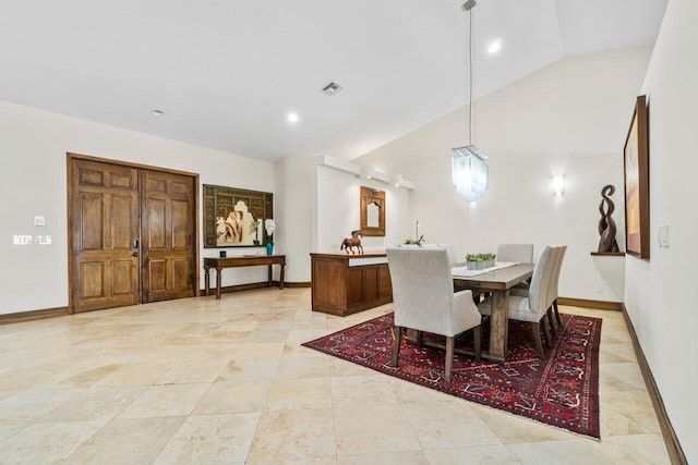 dining room featuring light tile floors and high vaulted ceiling