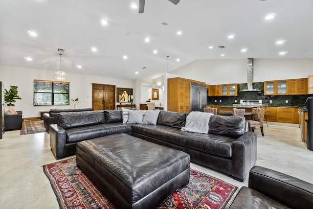 tiled living room with ceiling fan with notable chandelier and vaulted ceiling