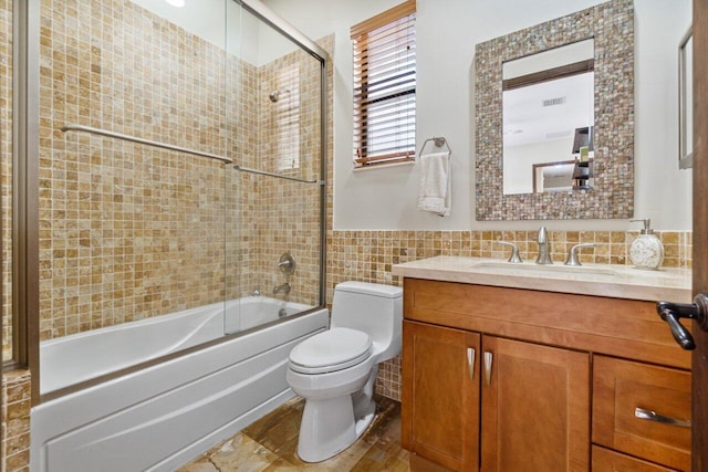 full bathroom with toilet, shower / bath combination with glass door, vanity, tasteful backsplash, and tile walls