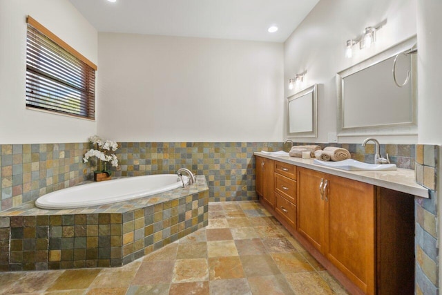 bathroom with a relaxing tiled bath, vanity, and tile floors