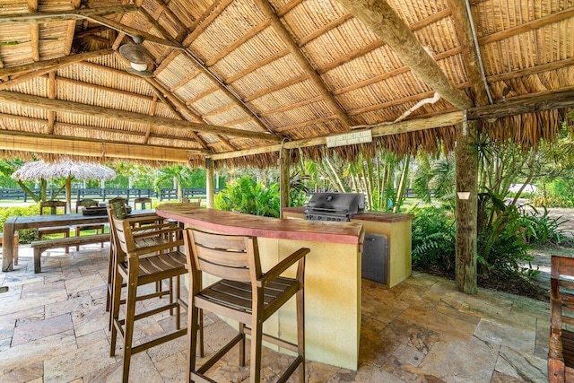 view of terrace featuring an outdoor bar, area for grilling, a gazebo, and a grill