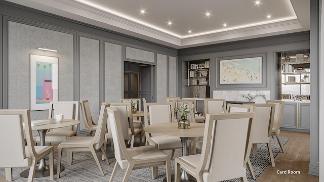 dining room with a raised ceiling, built in features, and dark hardwood / wood-style floors