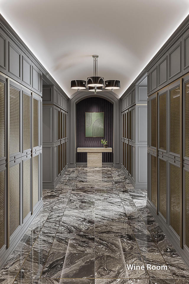 hallway featuring dark tile flooring and an inviting chandelier