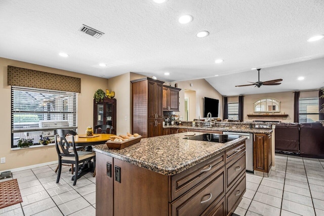 kitchen featuring a kitchen island, vaulted ceiling, ceiling fan, and light tile floors