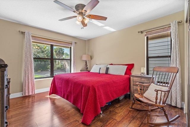 bedroom with dark hardwood / wood-style floors and ceiling fan