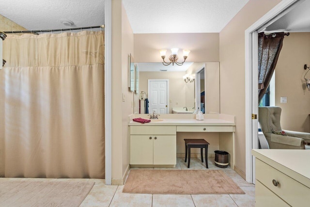 bathroom featuring oversized vanity, an inviting chandelier, a textured ceiling, and tile flooring