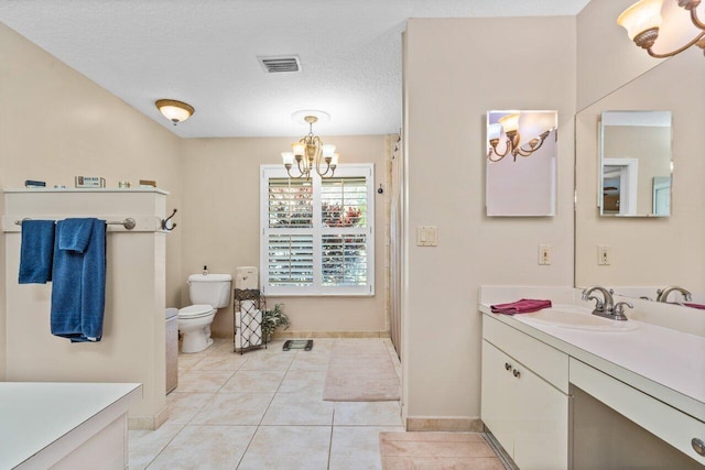 bathroom with toilet, vanity with extensive cabinet space, a chandelier, tile flooring, and a textured ceiling